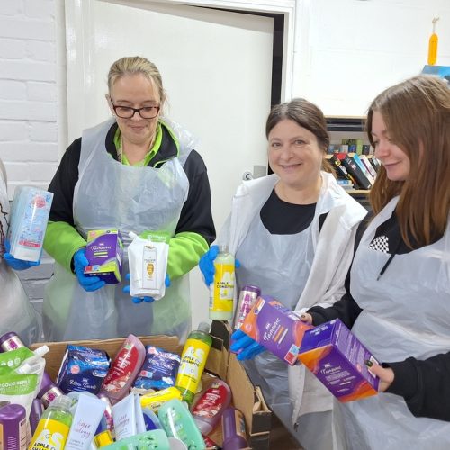 Four people sorting through hygiene donations