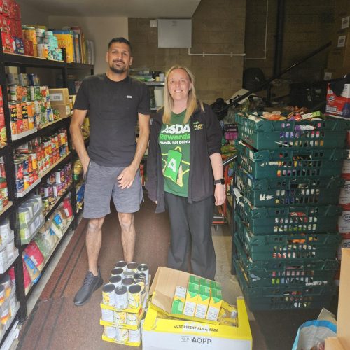 Two people stood in a foodbank pantry